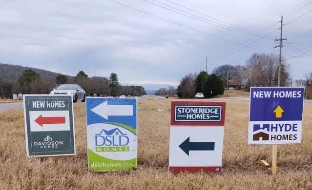 DSLD and Stoneridge Homes directional signs in a field